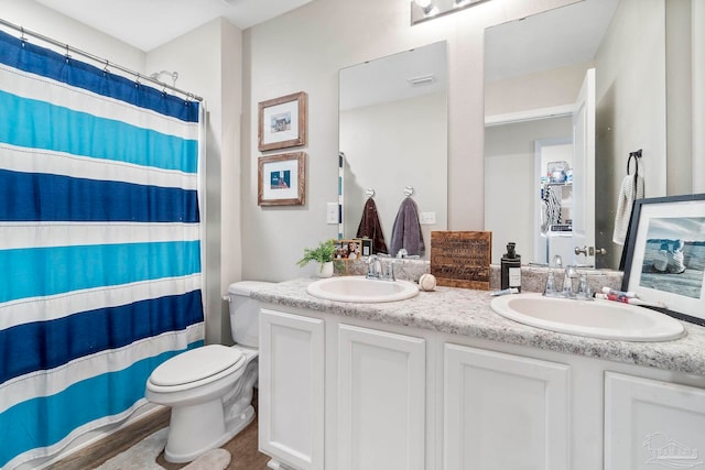 full bath featuring visible vents, double vanity, a sink, and toilet