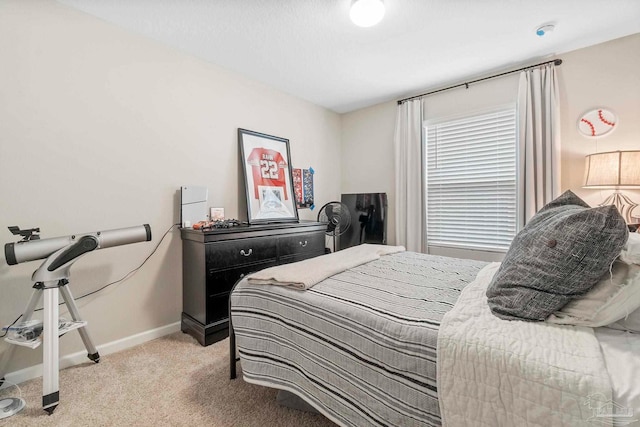 bedroom featuring light carpet and baseboards