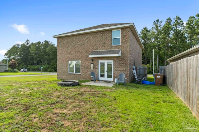 back of house with a yard, brick siding, a patio, and french doors