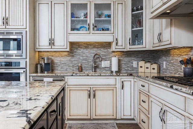 2 Bayou Blvd, Pensacola, FL 32503 - kitchen featuring light stone counters, a sink, under cabinet range hood, and stainless steel appliances