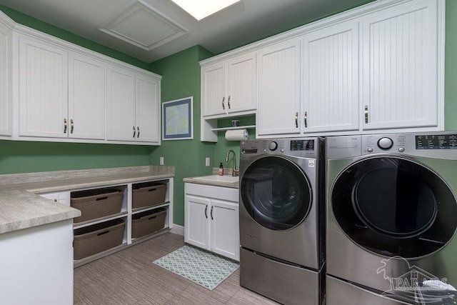 2 Bayou Blvd, Pensacola, FL 32503 - clothes washing area featuring cabinet space, washing machine and dryer, a sink, and light wood-type flooring