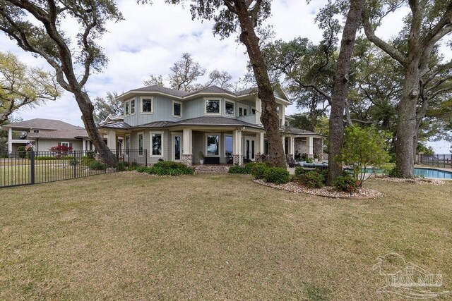 2 Bayou Blvd, Pensacola, FL 32503 - view of front of house featuring board and batten siding, fence, and a front yard
