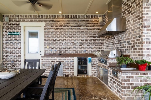 2 Bayou Blvd, Pensacola, FL 32503 - kitchen featuring ceiling fan, brick wall, a sink, beverage cooler, and wall chimney exhaust hood