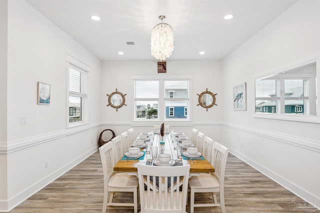 dining space with hardwood / wood-style flooring, a chandelier, and plenty of natural light