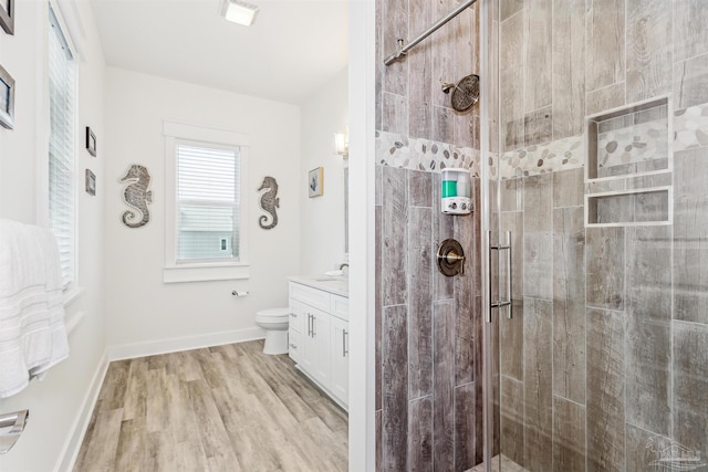 bathroom featuring vanity, toilet, an enclosed shower, and hardwood / wood-style floors