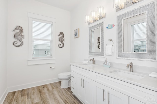 bathroom with toilet, hardwood / wood-style floors, vanity, and plenty of natural light