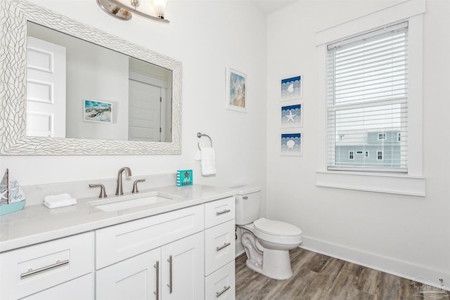 7395 Grand Navarre Blvd, Navarre Beach, FL 32566 - bathroom featuring toilet, wood finished floors, vanity, and baseboards