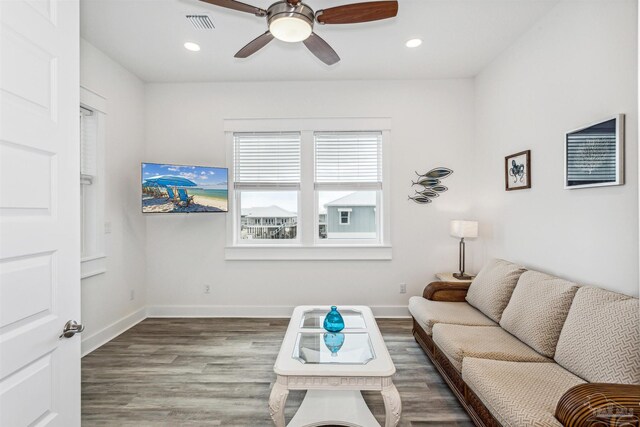 living room featuring hardwood / wood-style floors and ceiling fan