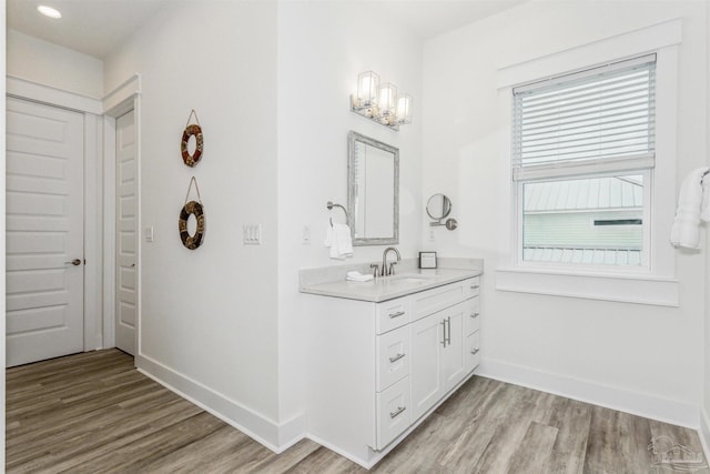 7395 Grand Navarre Blvd, Navarre Beach, FL 32566 - bathroom featuring wood finished floors, baseboards, vanity, and recessed lighting