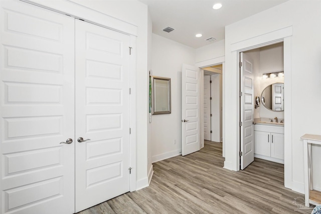 hallway featuring light hardwood / wood-style floors and sink