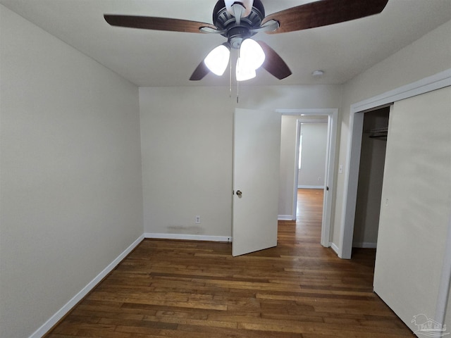 unfurnished bedroom featuring dark wood-type flooring, ceiling fan, and a closet