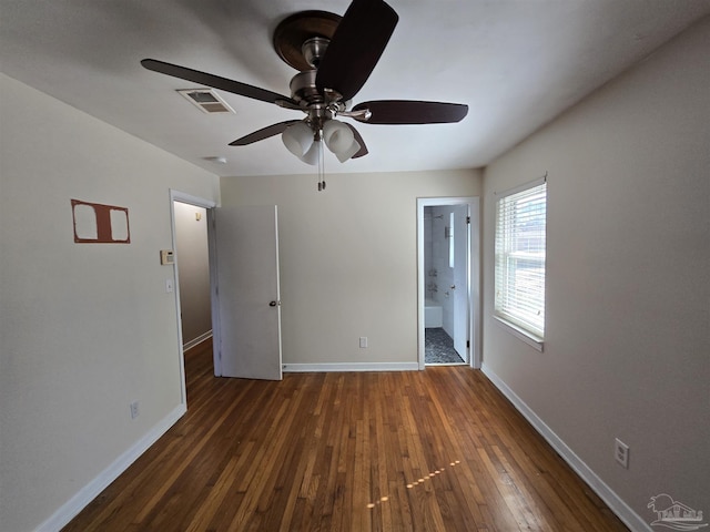 unfurnished bedroom featuring ceiling fan, connected bathroom, and dark hardwood / wood-style floors