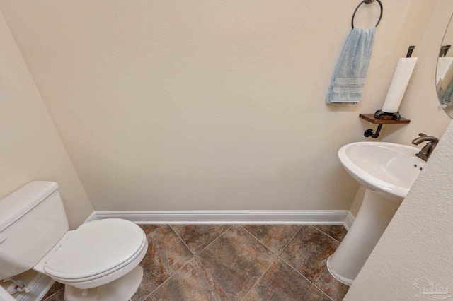 bathroom with toilet and tile patterned floors