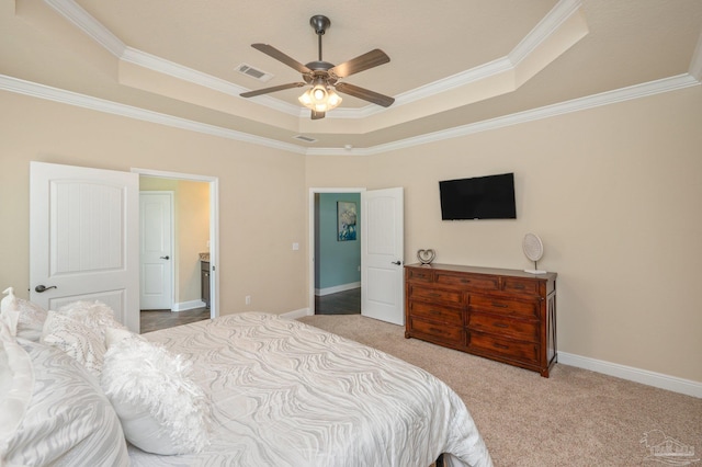 bedroom featuring ceiling fan, ornamental molding, a tray ceiling, and light colored carpet