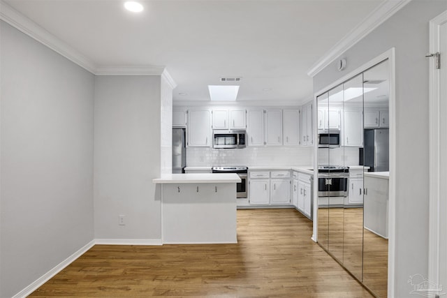 3108 Station Ct, Pensacola, FL 32504 - kitchen featuring stainless steel appliances, backsplash, light countertops, ornamental molding, and light wood finished floors
