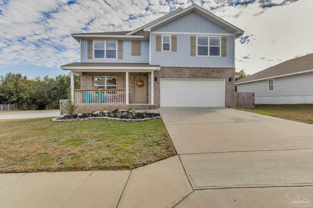 view of front of property featuring a garage, a front yard, and a porch