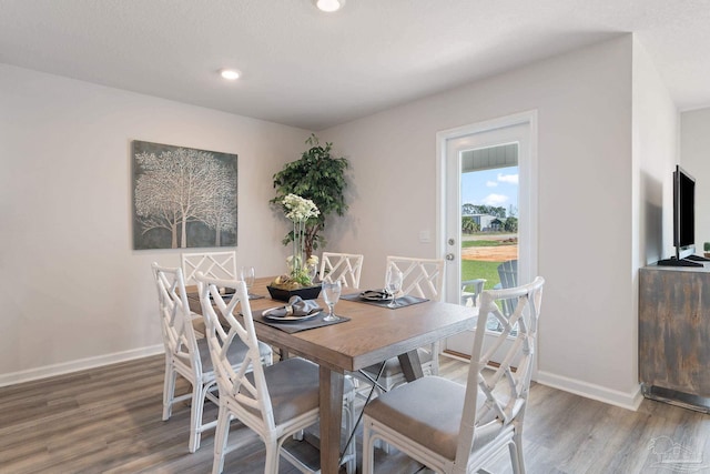 dining space featuring recessed lighting, baseboards, and wood finished floors