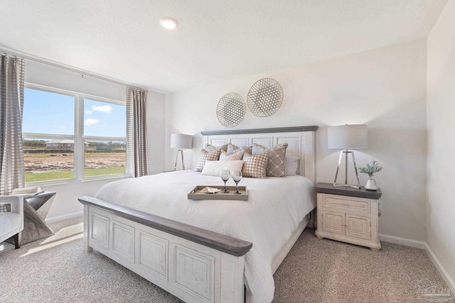 bedroom featuring baseboards and light carpet