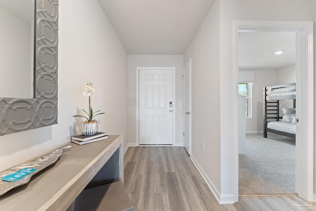 corridor with light wood-style flooring and baseboards