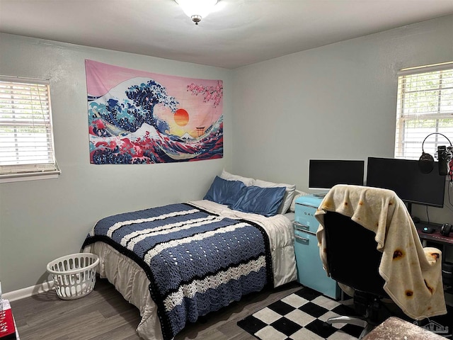 bedroom featuring multiple windows and dark hardwood / wood-style floors