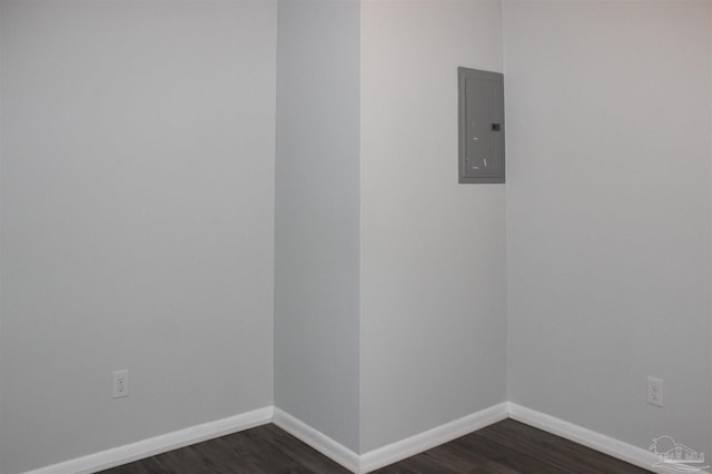 spare room featuring dark wood-type flooring and electric panel