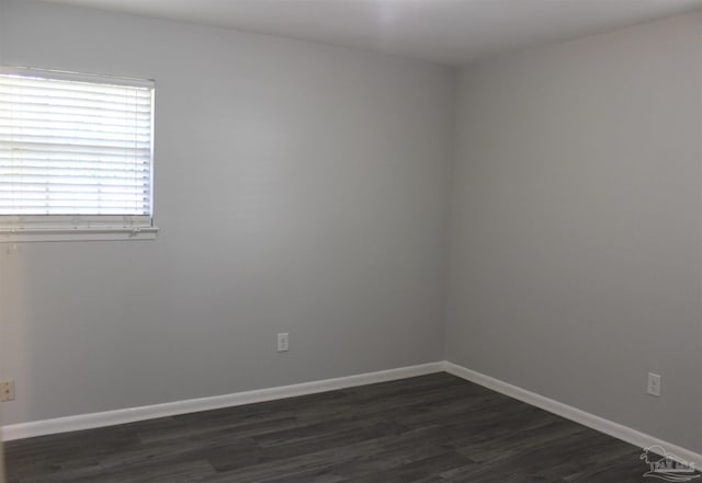 empty room with dark hardwood / wood-style flooring