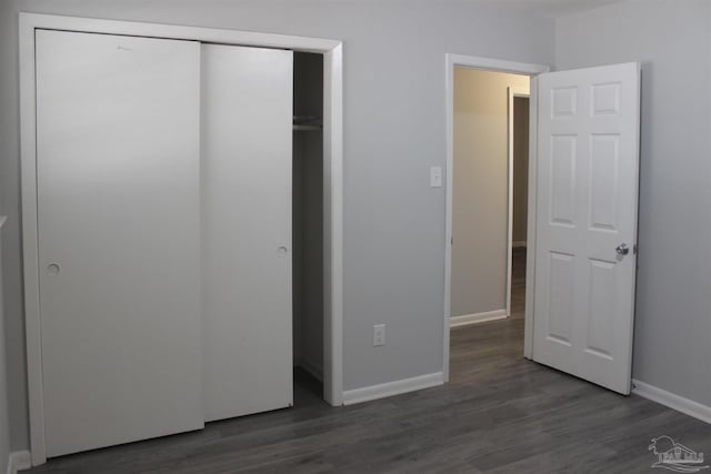 unfurnished bedroom featuring dark hardwood / wood-style flooring and a closet