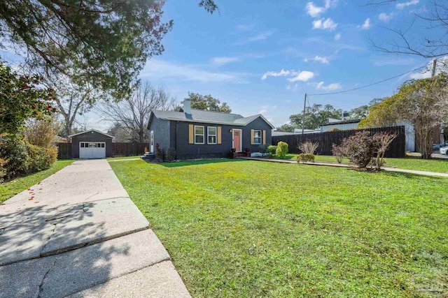 view of front of home featuring an outbuilding, concrete driveway, fence, a garage, and a front lawn