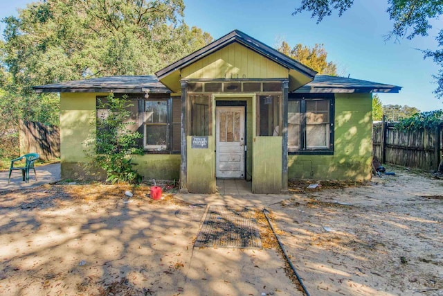 bungalow-style home featuring fence