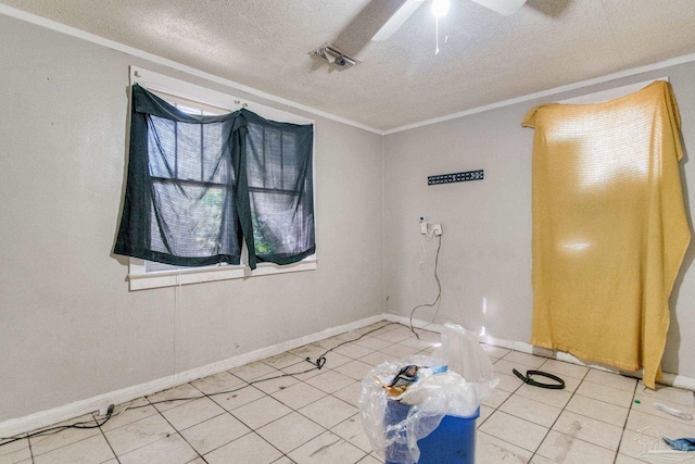 spare room with a textured ceiling, a ceiling fan, visible vents, and ornamental molding