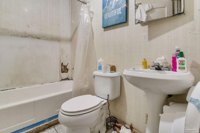 full bath with tile patterned floors, toilet, tile walls, and shower / bath combo