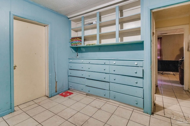 spare room featuring light tile patterned floors and a textured ceiling