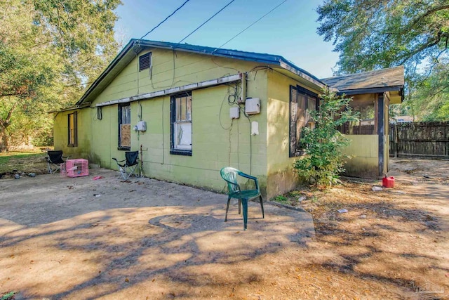 view of property exterior with a patio area and fence