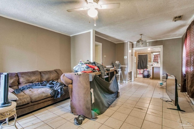 living area with ceiling fan, a textured ceiling, light tile patterned flooring, and crown molding