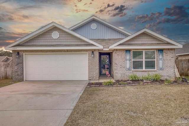 view of front of home with a garage and a lawn