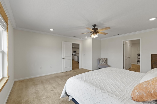 bedroom featuring ceiling fan, light colored carpet, ornamental molding, and ensuite bathroom