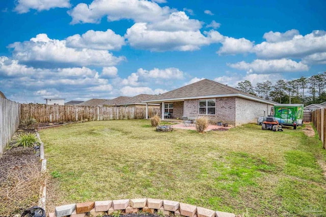 rear view of property featuring a yard and a patio area