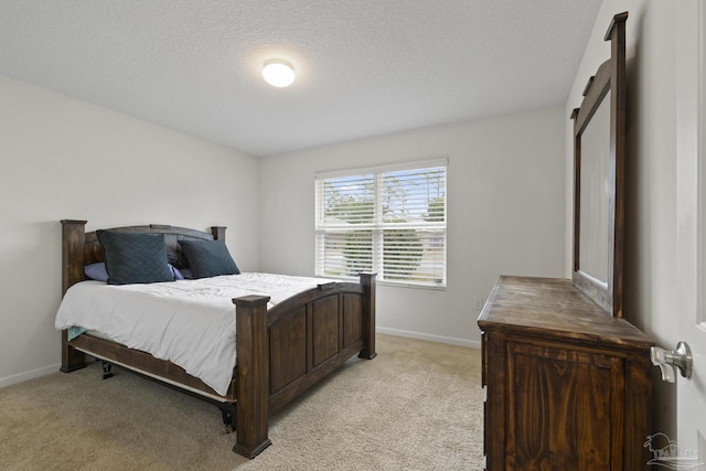 bedroom featuring light colored carpet and a textured ceiling