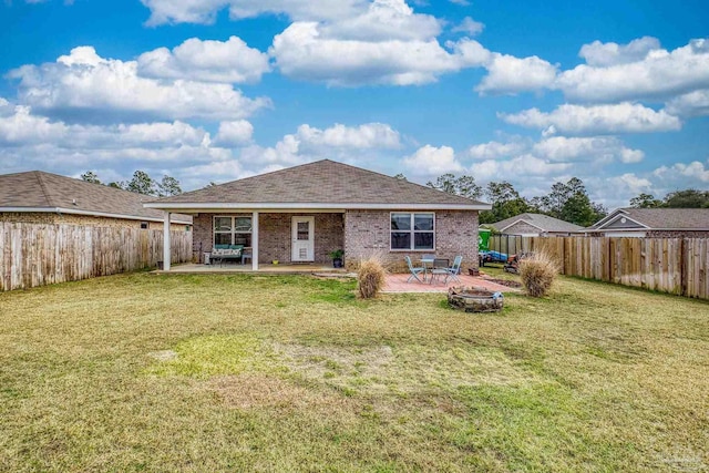 back of house featuring a patio area, a yard, and a fire pit