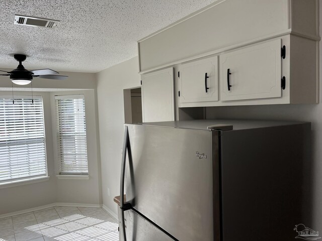 kitchen featuring white cabinets, plenty of natural light, visible vents, and freestanding refrigerator