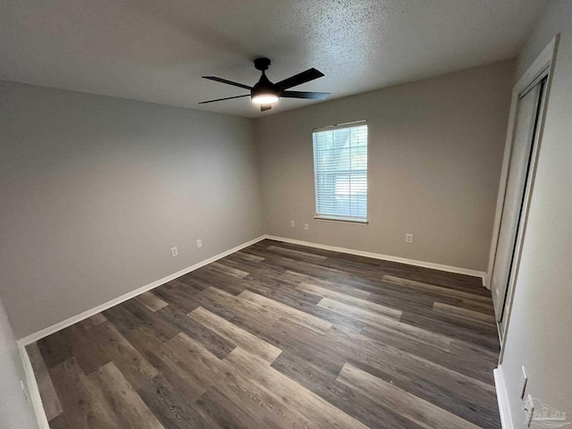 unfurnished bedroom with a ceiling fan, baseboards, dark wood-style flooring, and a closet