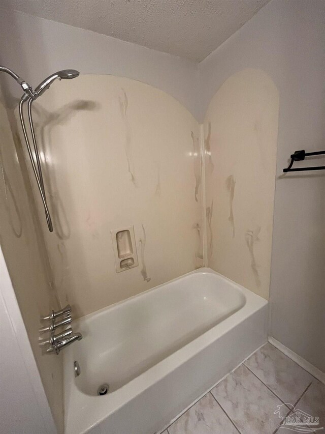 bathroom with shower / tub combination and a textured ceiling