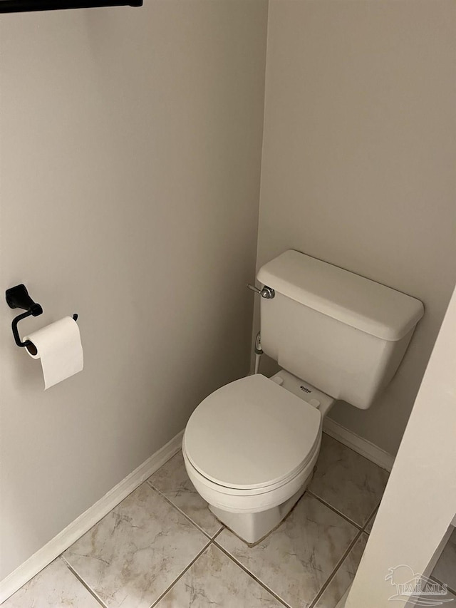 bathroom featuring toilet, baseboards, and marble finish floor