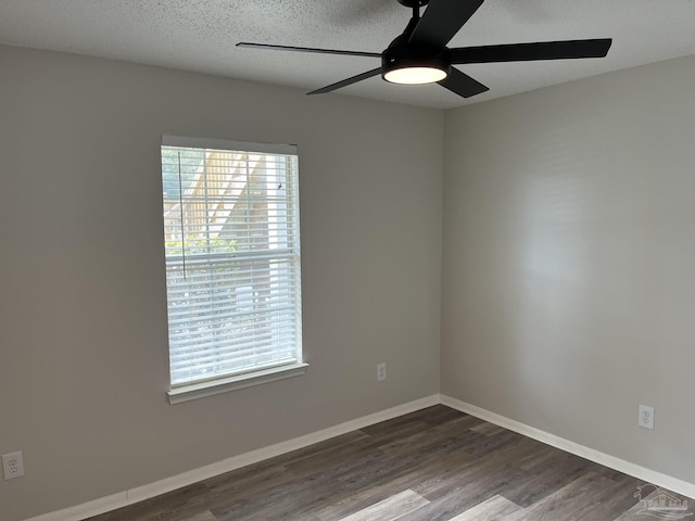 unfurnished room featuring baseboards, a healthy amount of sunlight, ceiling fan, and dark wood-style flooring