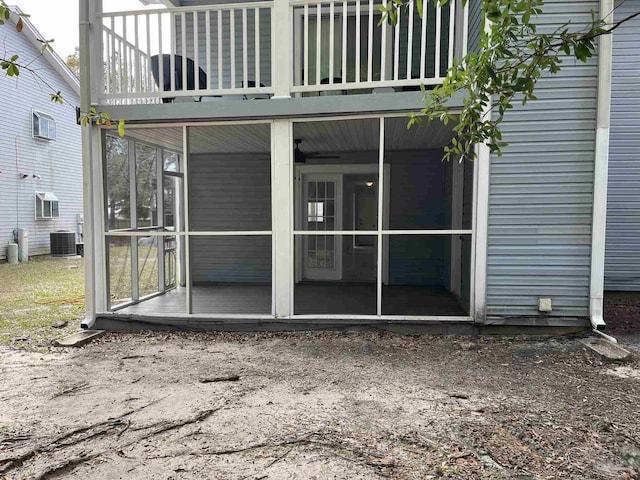 exterior space with central AC unit and a sunroom