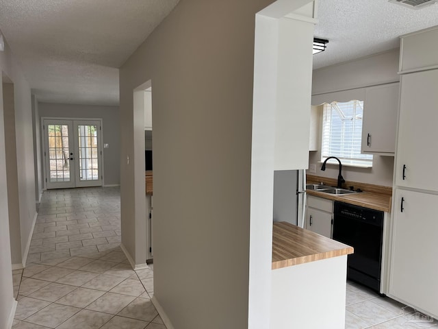 interior space with a sink, french doors, a healthy amount of sunlight, and light tile patterned flooring