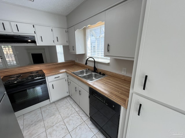 kitchen with black appliances, a sink, under cabinet range hood, a textured ceiling, and white cabinetry