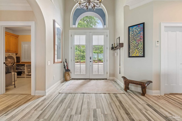 doorway featuring light wood-type flooring, baseboards, ornamental molding, and french doors