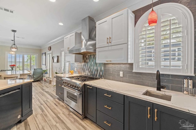 kitchen featuring crown molding, tasteful backsplash, visible vents, wall chimney range hood, and high end range