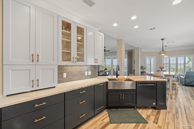 kitchen featuring black dishwasher, visible vents, backsplash, white cabinetry, and a sink